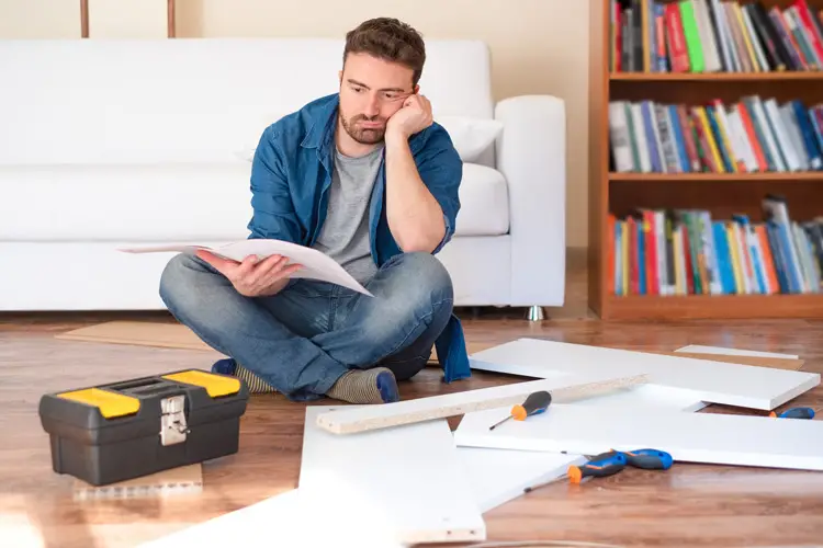 man trying to understand instructions for furniture project